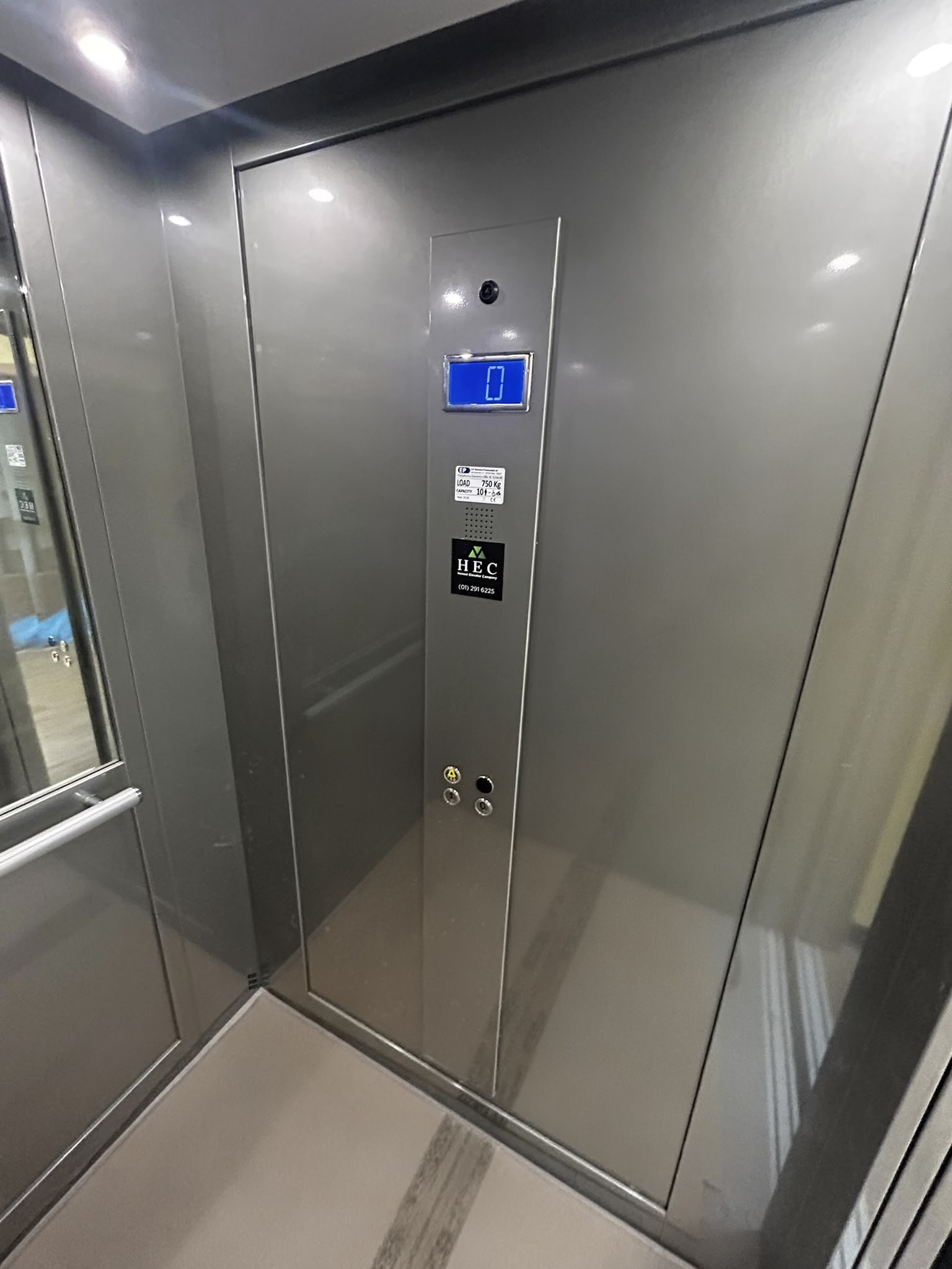Lift interior with stainless steel operating panel, handrail and ceiling lighting