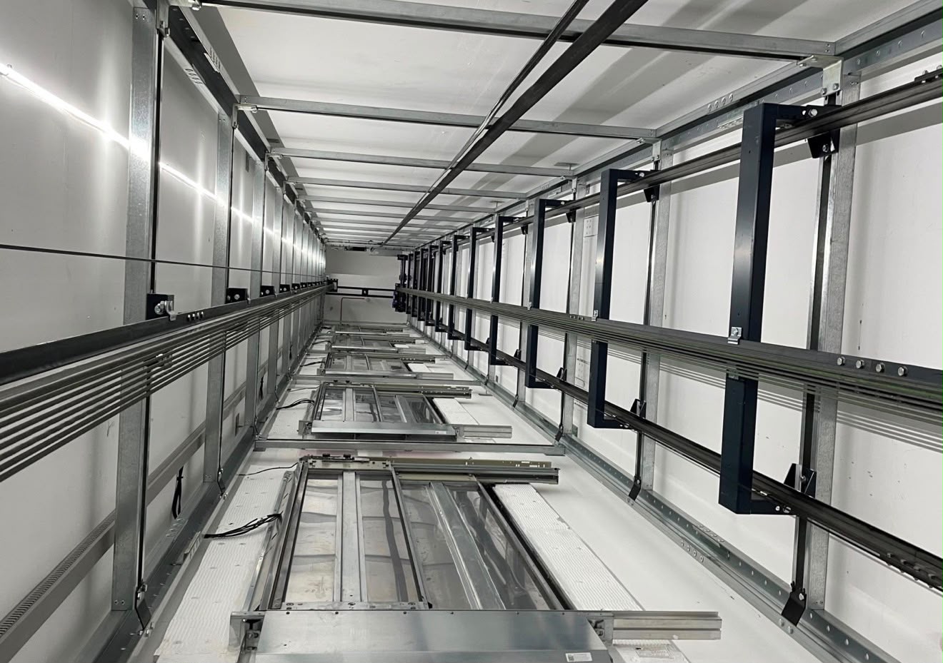 View along a lift shaft showing guide rails and cables